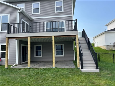 Elevated composite deck with support posts and staircase installed on Apple Valley residence