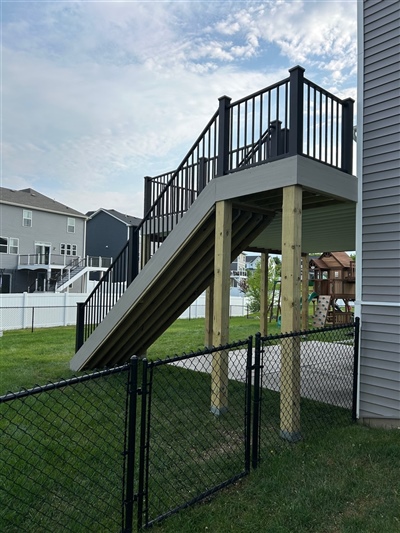 Side view of Apple Valley deck installation with structural support posts and stairway