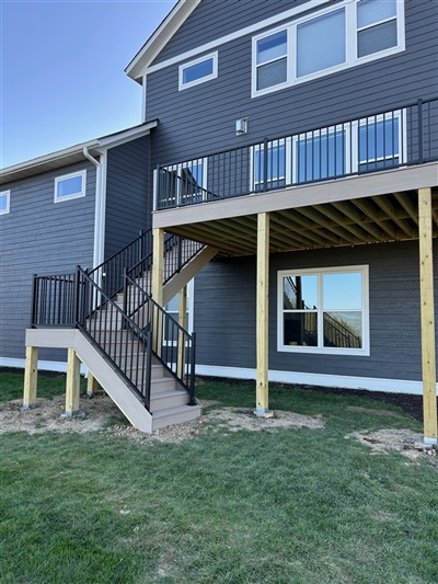 Elevated composite deck with stair access and structural posts installed in Long Lake home