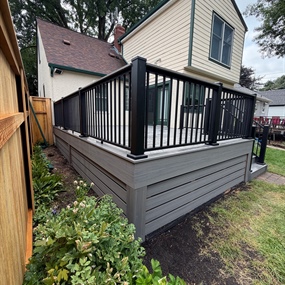 Minneapolis composite deck rebuild with Deckorators Sierra decking, black railing, and enclosed lower perimeter
